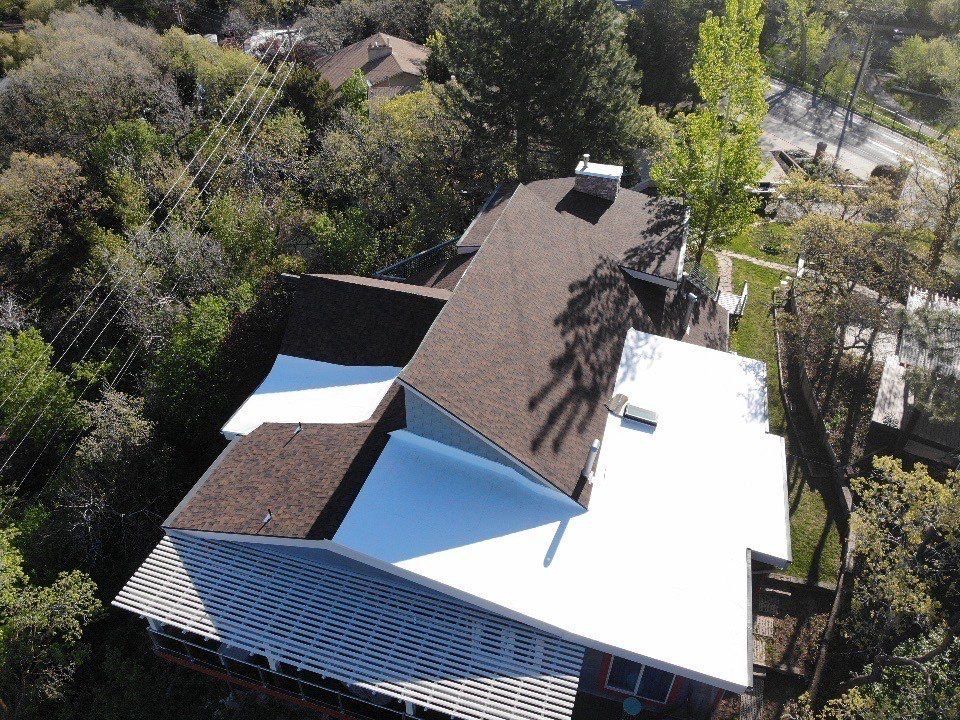 An aerial view of a house with a white roof