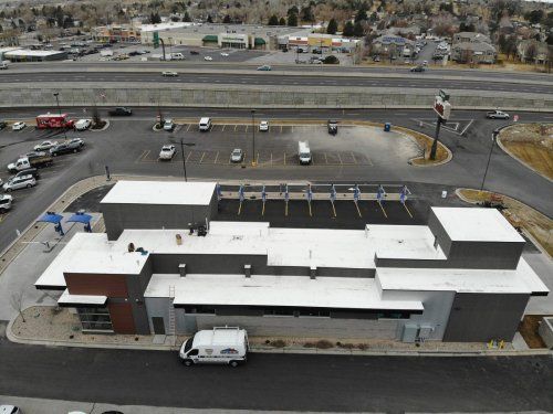 An aerial view of a building with a white van parked in front of it.