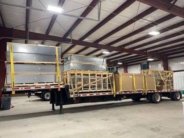 Construction worker welding metal decking on a building frame, sparks flying. Outdoors.