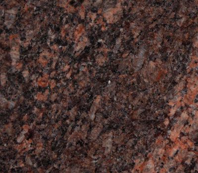 Red-brown granite with dark spots and speckled pattern, possibly for countertop or flooring.