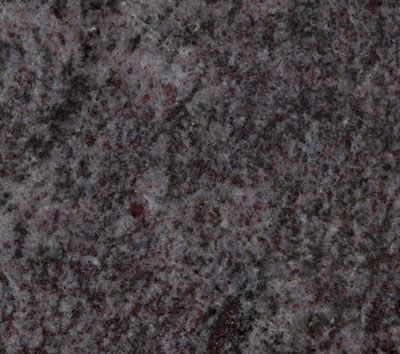 Close-up of a granite countertop with a speckled pattern in shades of gray and maroon.