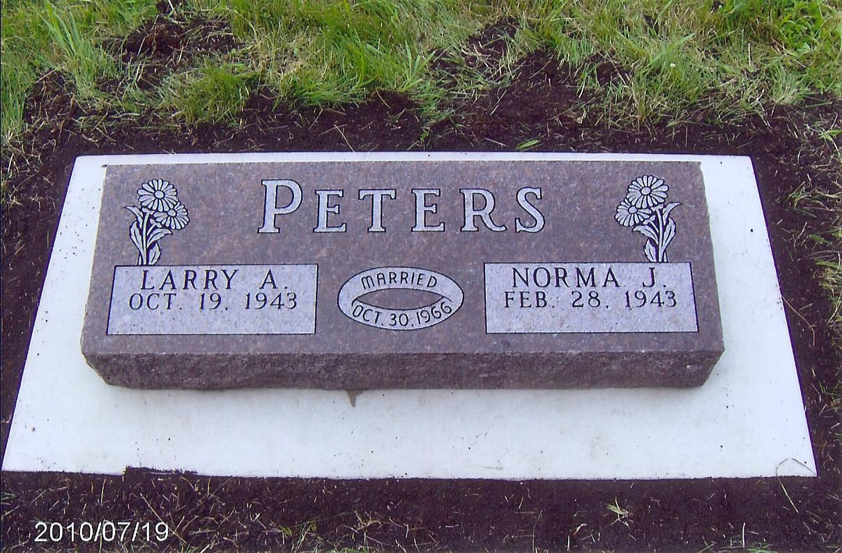 Gravestone for Peters family. Dark granite stone with names, dates, and tree designs.