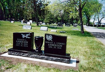 Black headstones in a cemetery, with an urn in the center. The stones commemorate Kenneth J. Anderson and Shirley J. (DODDKE) Anderson.
