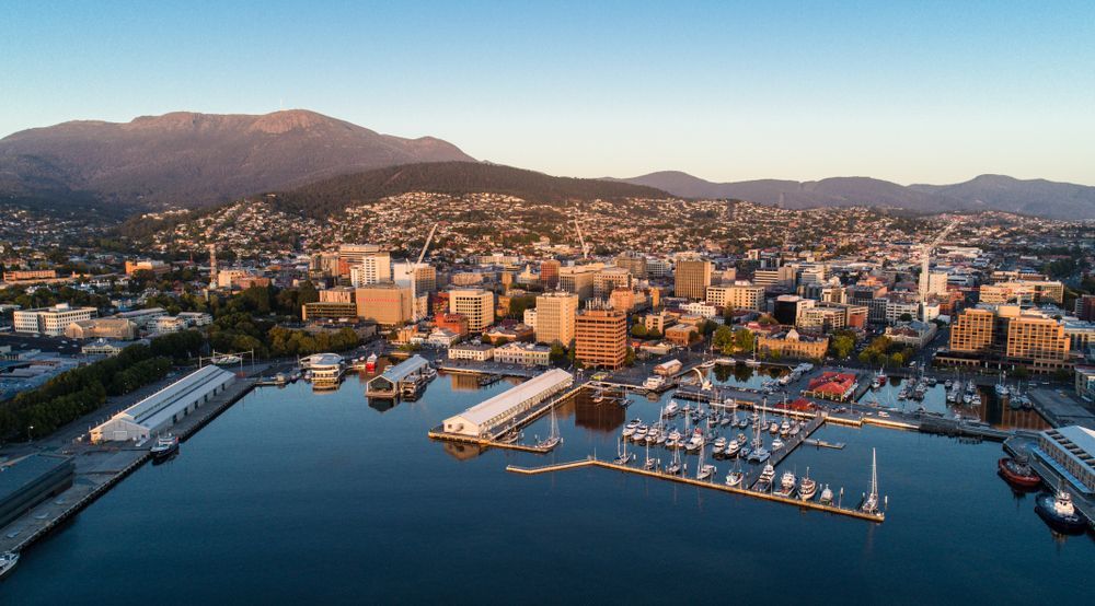 An Aerial View Of A City With A Harbor And Mountains In The Background — Tradie Books Australia In Hobart, TAS