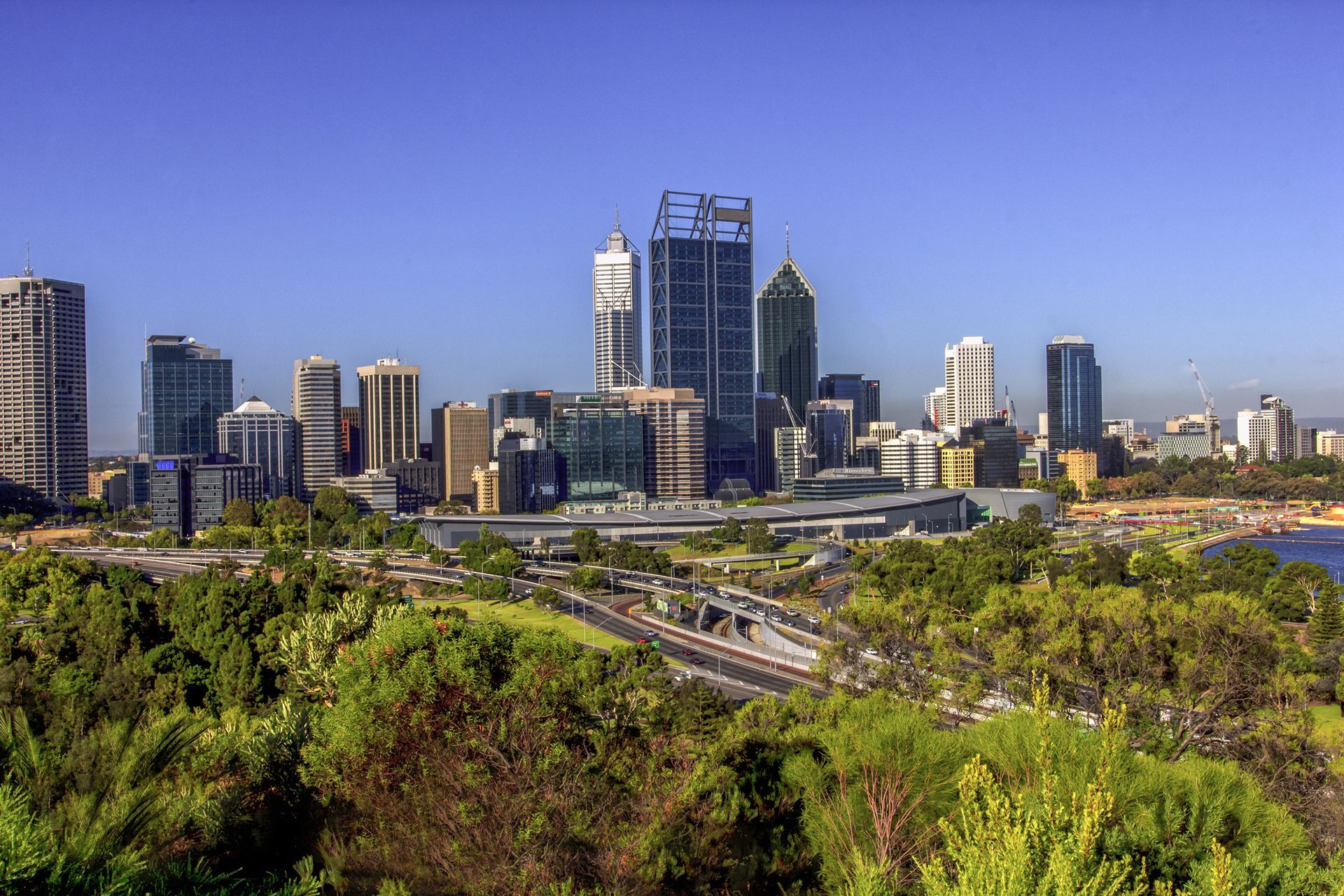 A City Skyline With Trees In The Foreground And A River In The Background — Tradie Books Australia In Perth, WA