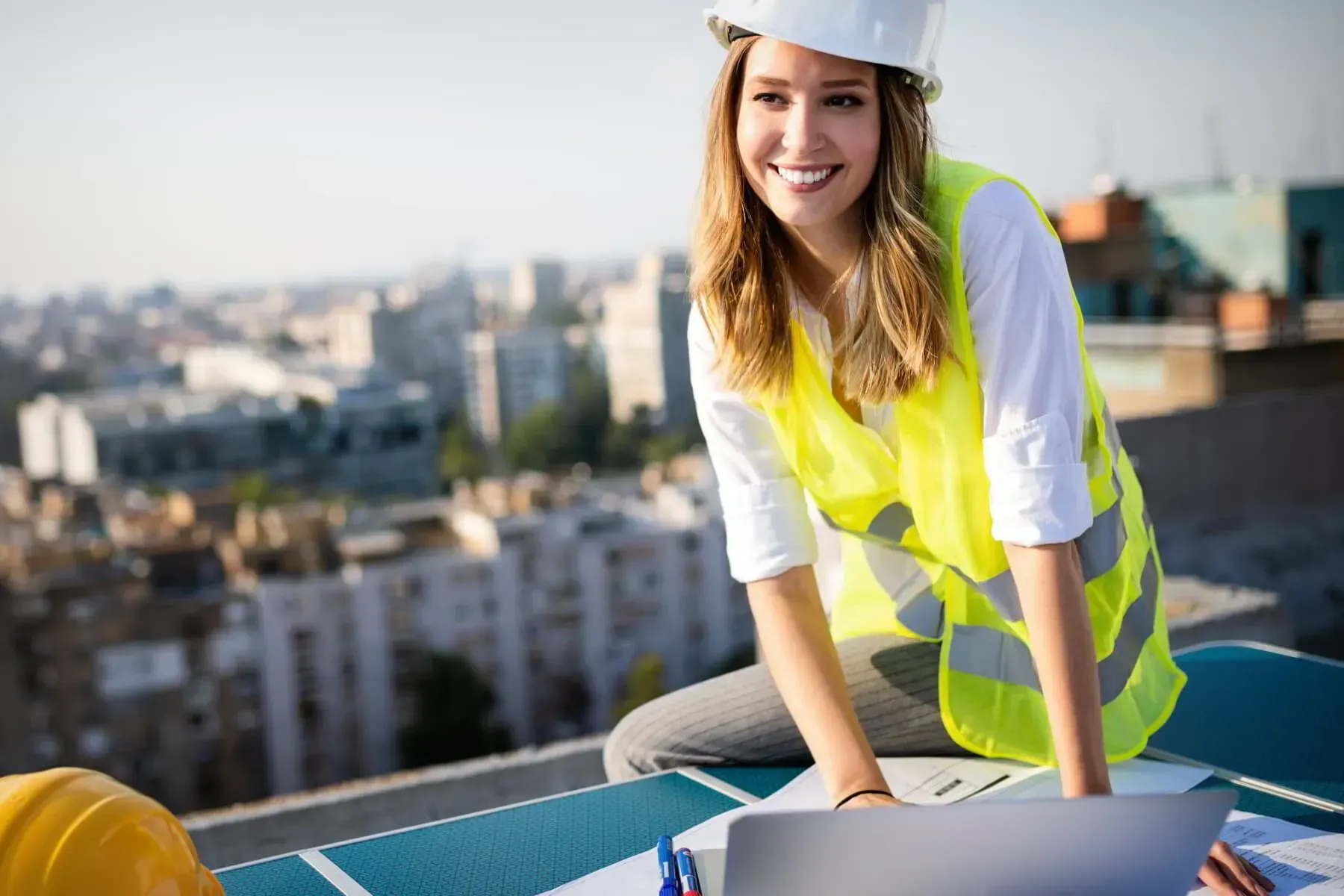 A Woman Is Sitting On A Roof Using A Laptop Computer — Tradie Books Australia In Port Kennedy, WA