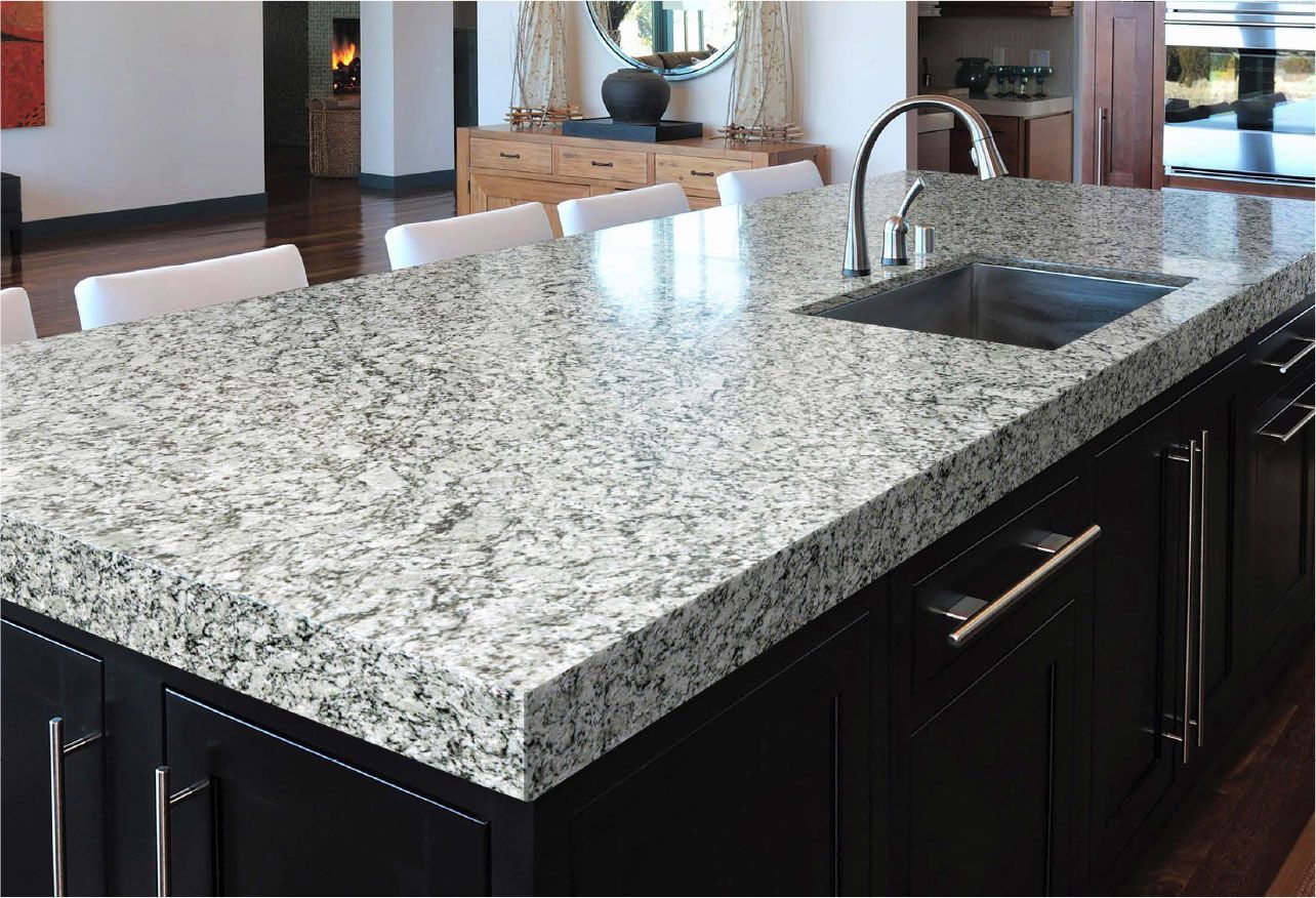 A kitchen with a large granite counter top and a sink.