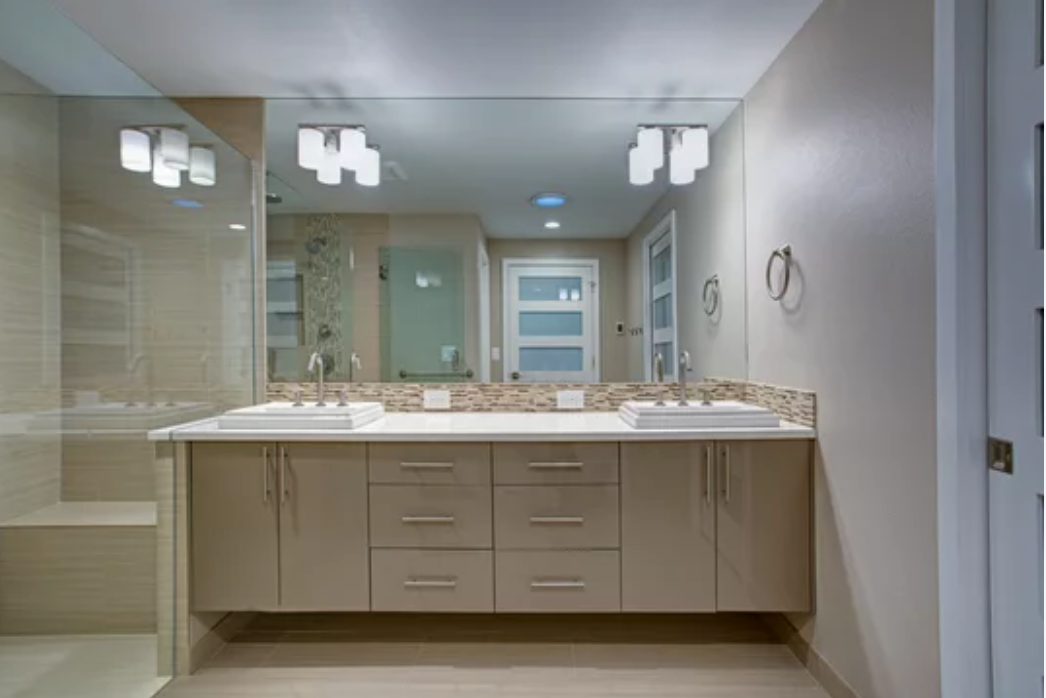 A bathroom with two sinks and a large mirror.