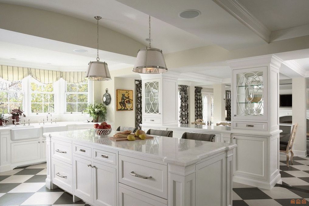 A kitchen with white cabinets and a large island in the middle