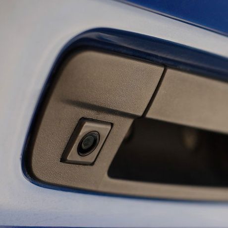 A close up of a car door handle with a camera on it
