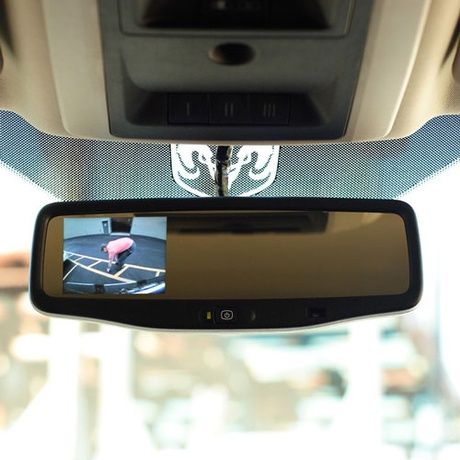 A rear view mirror with a monitor attached to it