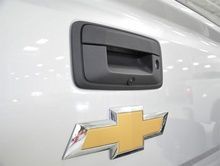 The back of a white chevrolet truck with a chevrolet logo on it.