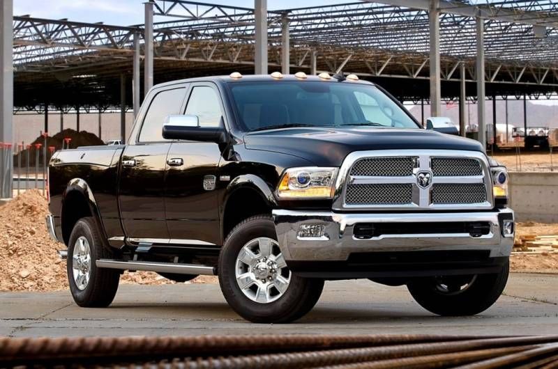 A black dodge ram truck is parked in front of a building under construction.