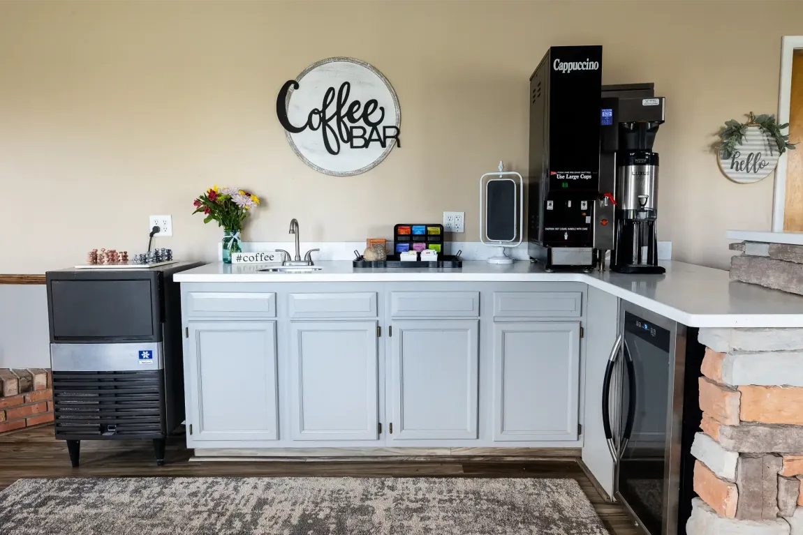A kitchen with a coffee bar and a sink.
