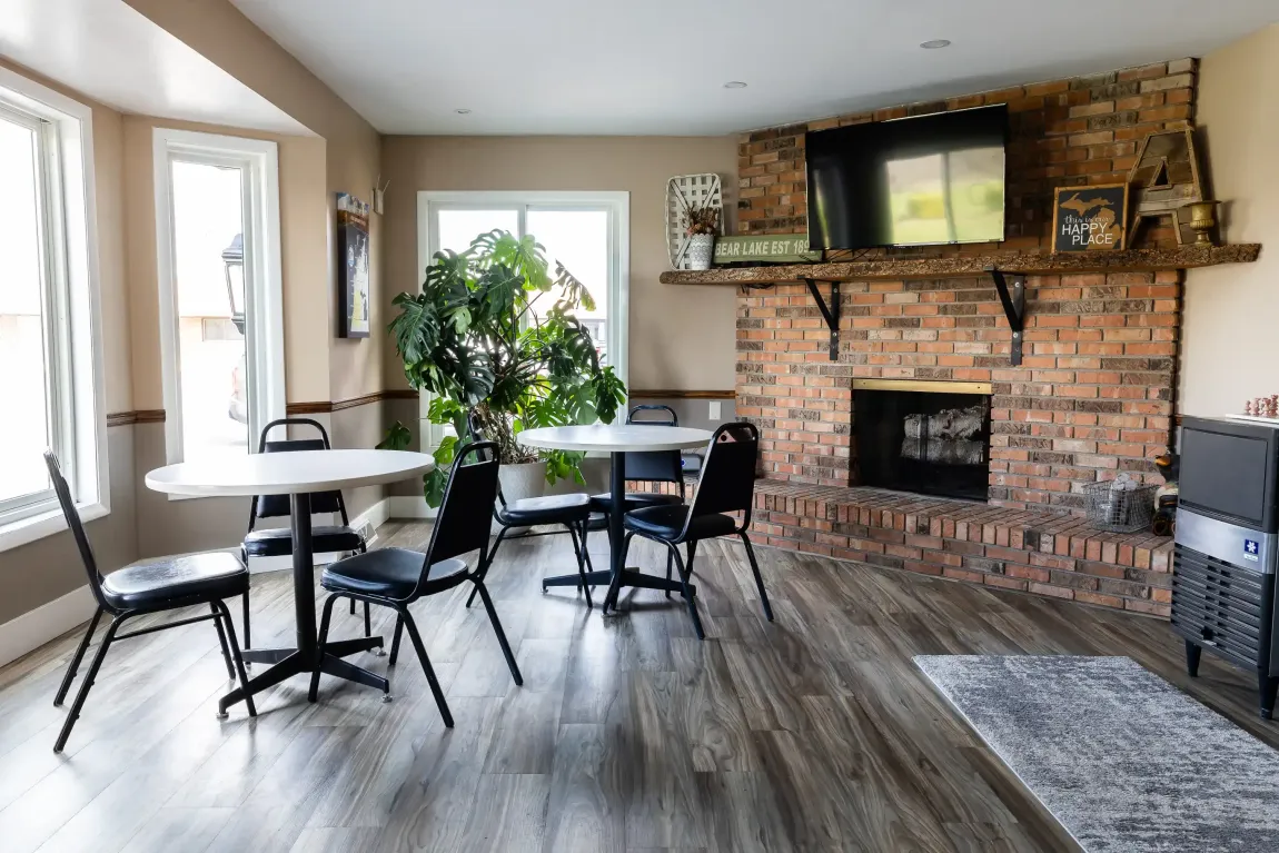 A living room with tables and chairs and a fireplace.