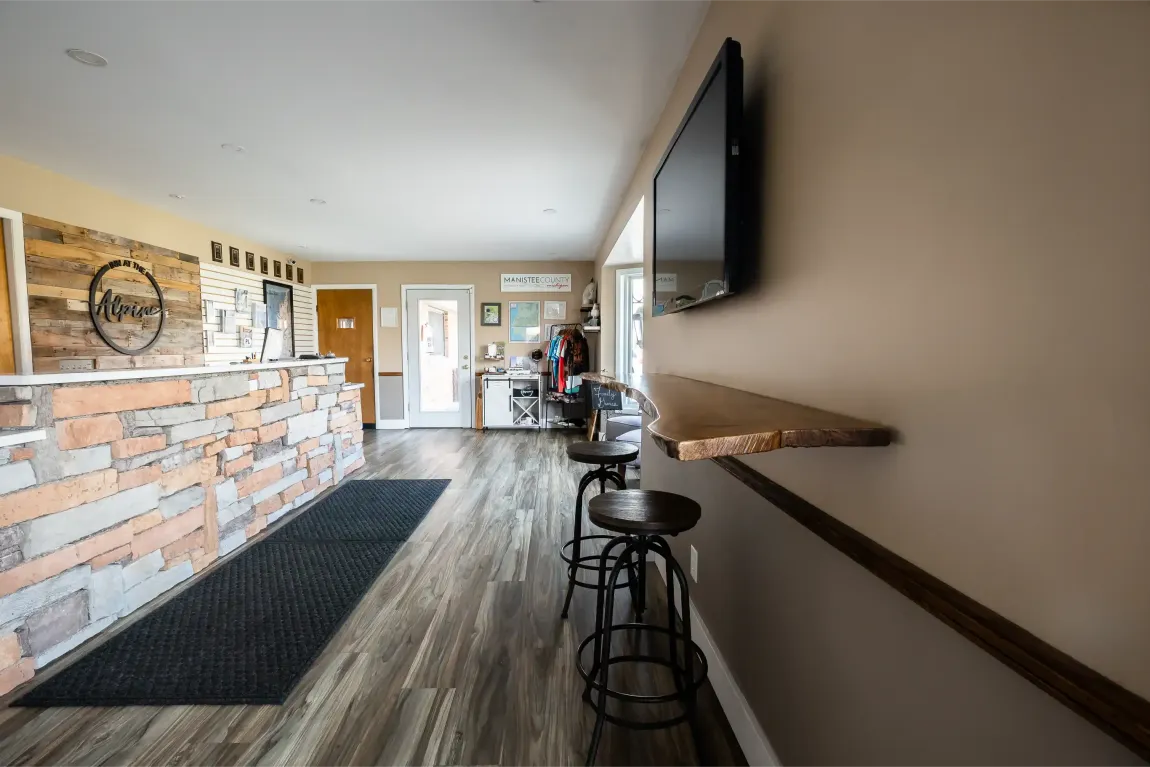 A hotel lobby with a brick wall and a flat screen tv on the wall.