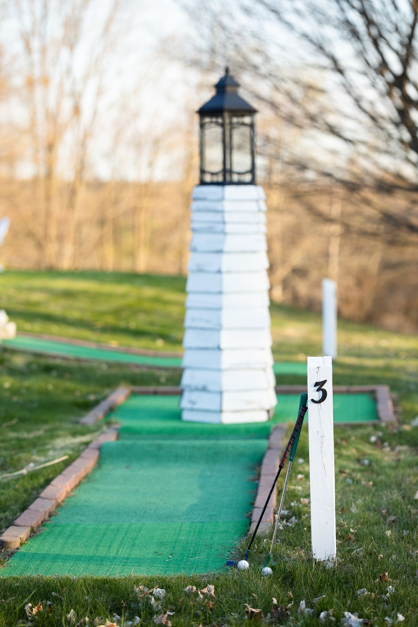 A lighthouse is sitting on top of a mini golf course.