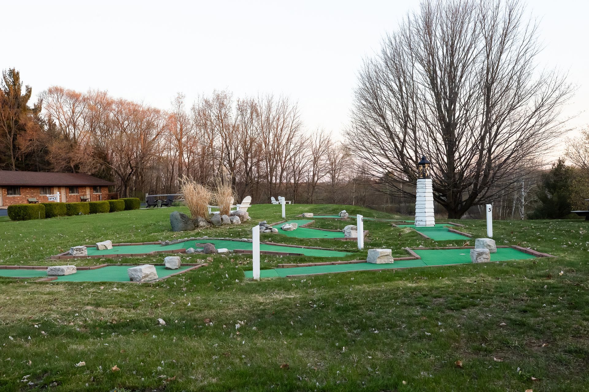 A mini golf course in a grassy field with trees in the background
