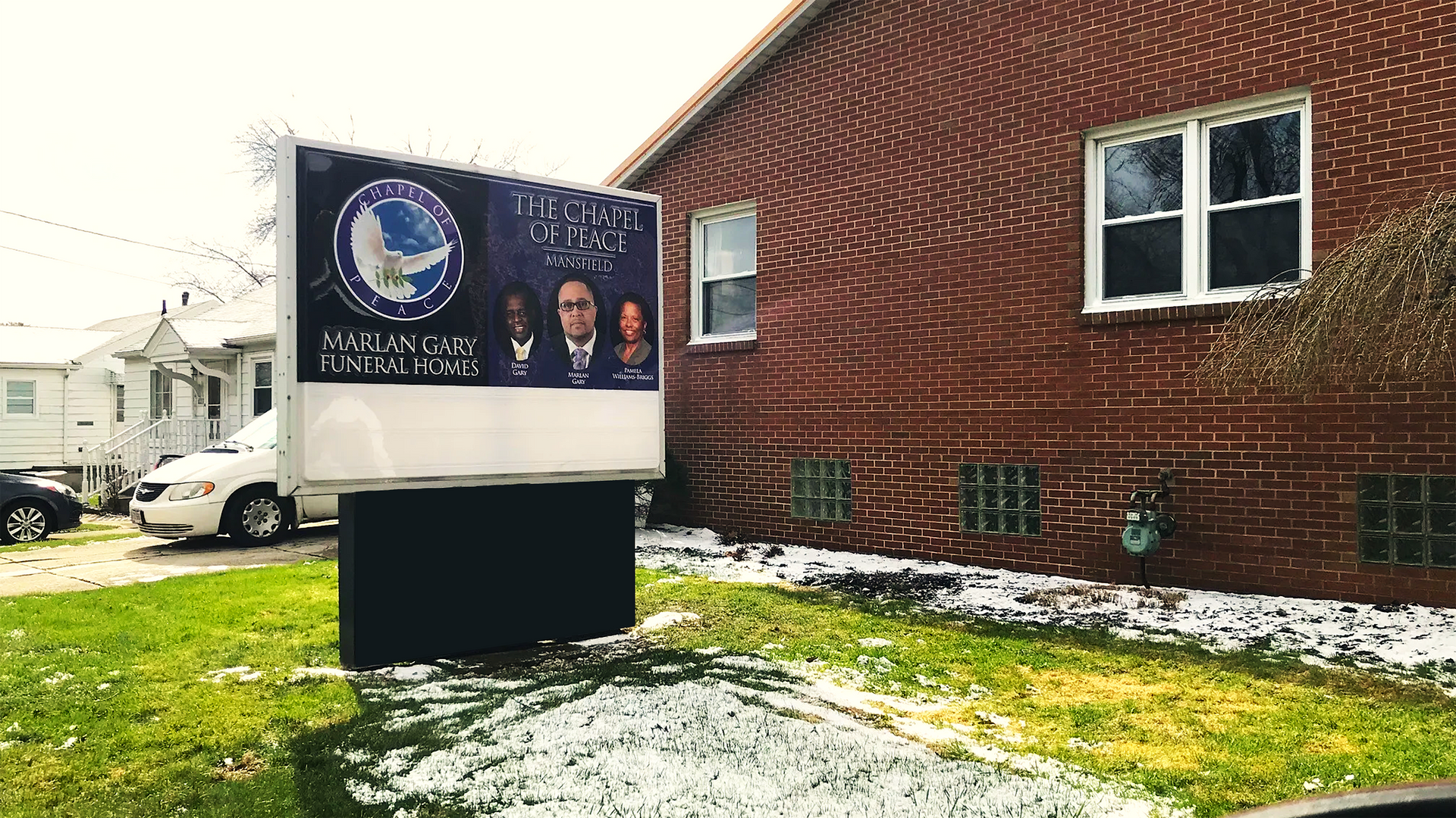 A brick building with a sign in front of it.