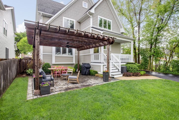 Backyard patio with a pergola over furniture