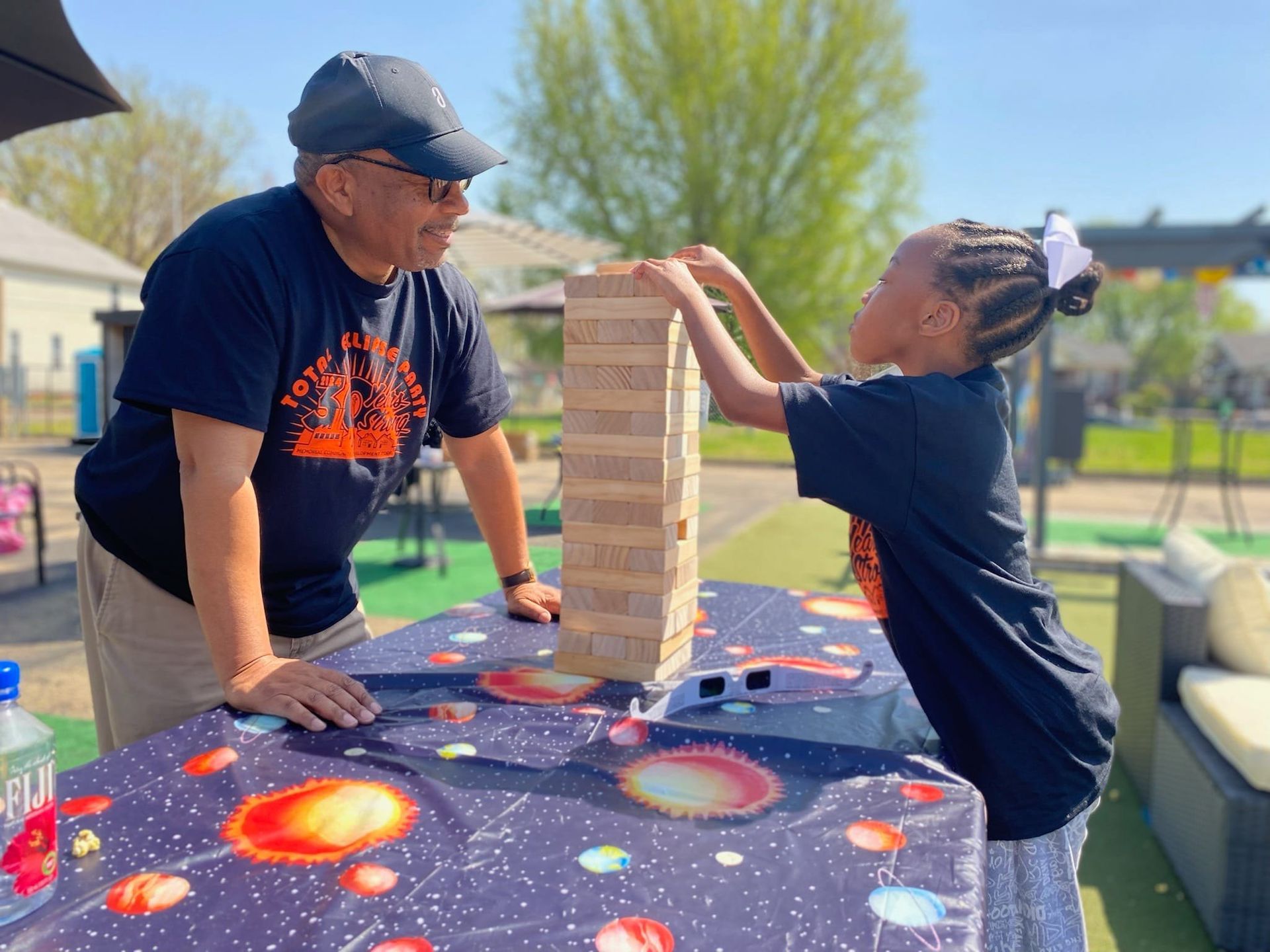 A woman is sitting at a bar holding two drinks.