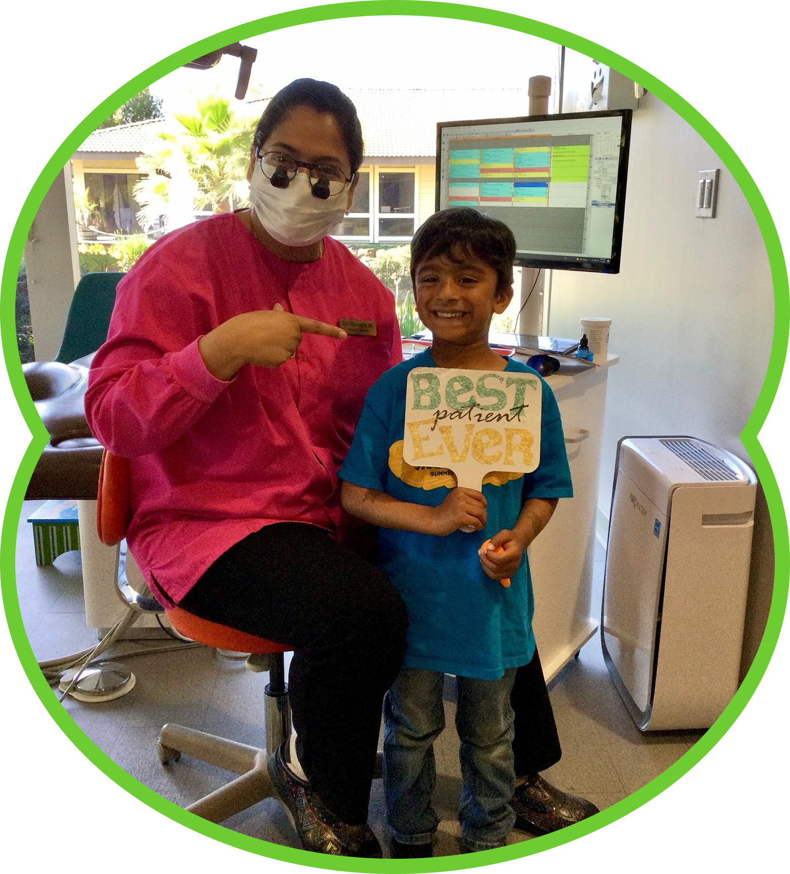 Dentist points to toothbrush with smiling child holding 