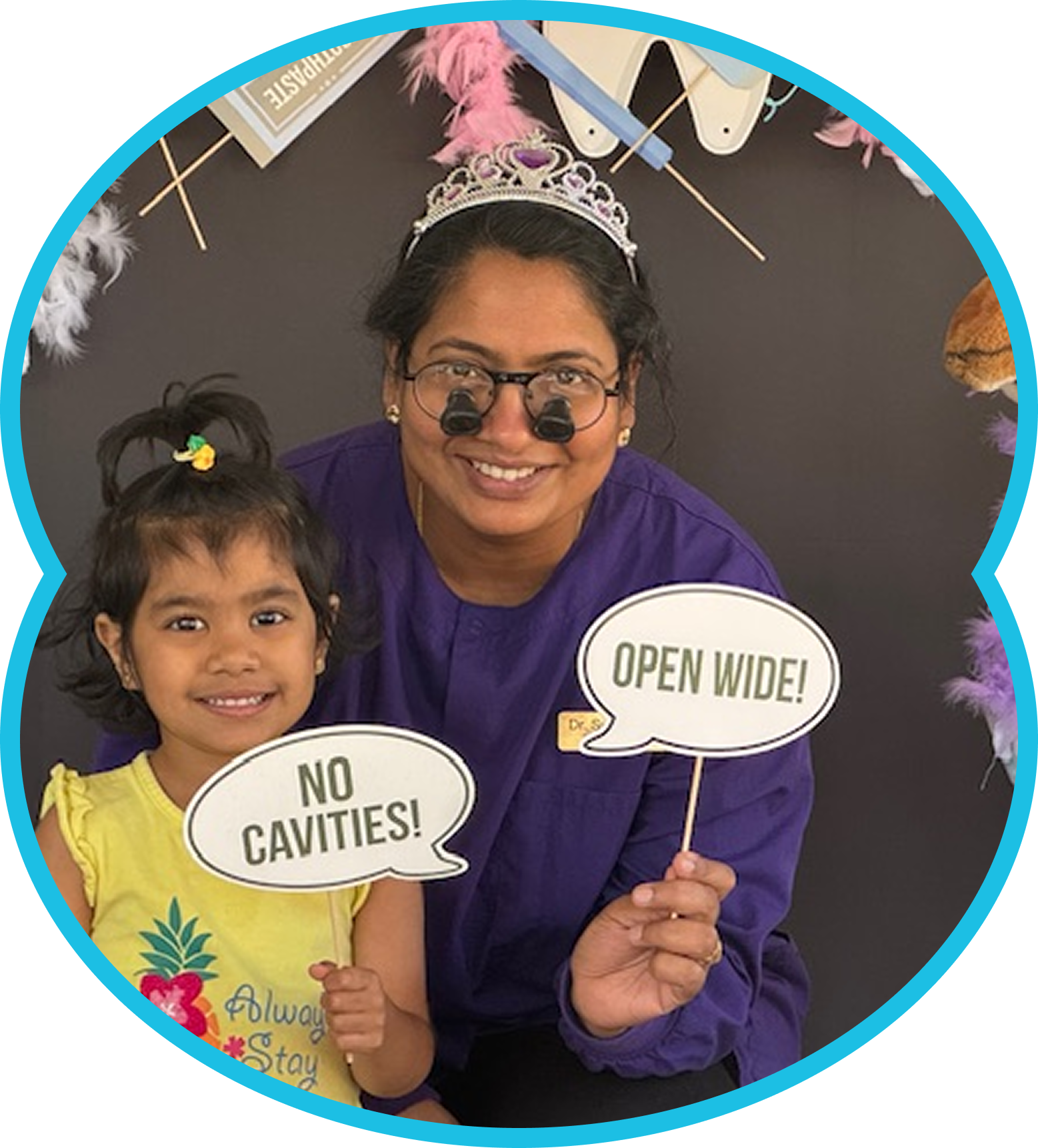 Woman with dental loupes and child holding speech bubbles that say 