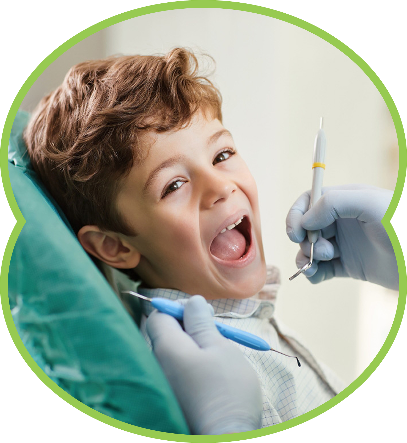 Boy with open mouth at a dentist appointment, dentist tools in mouth, green chair.