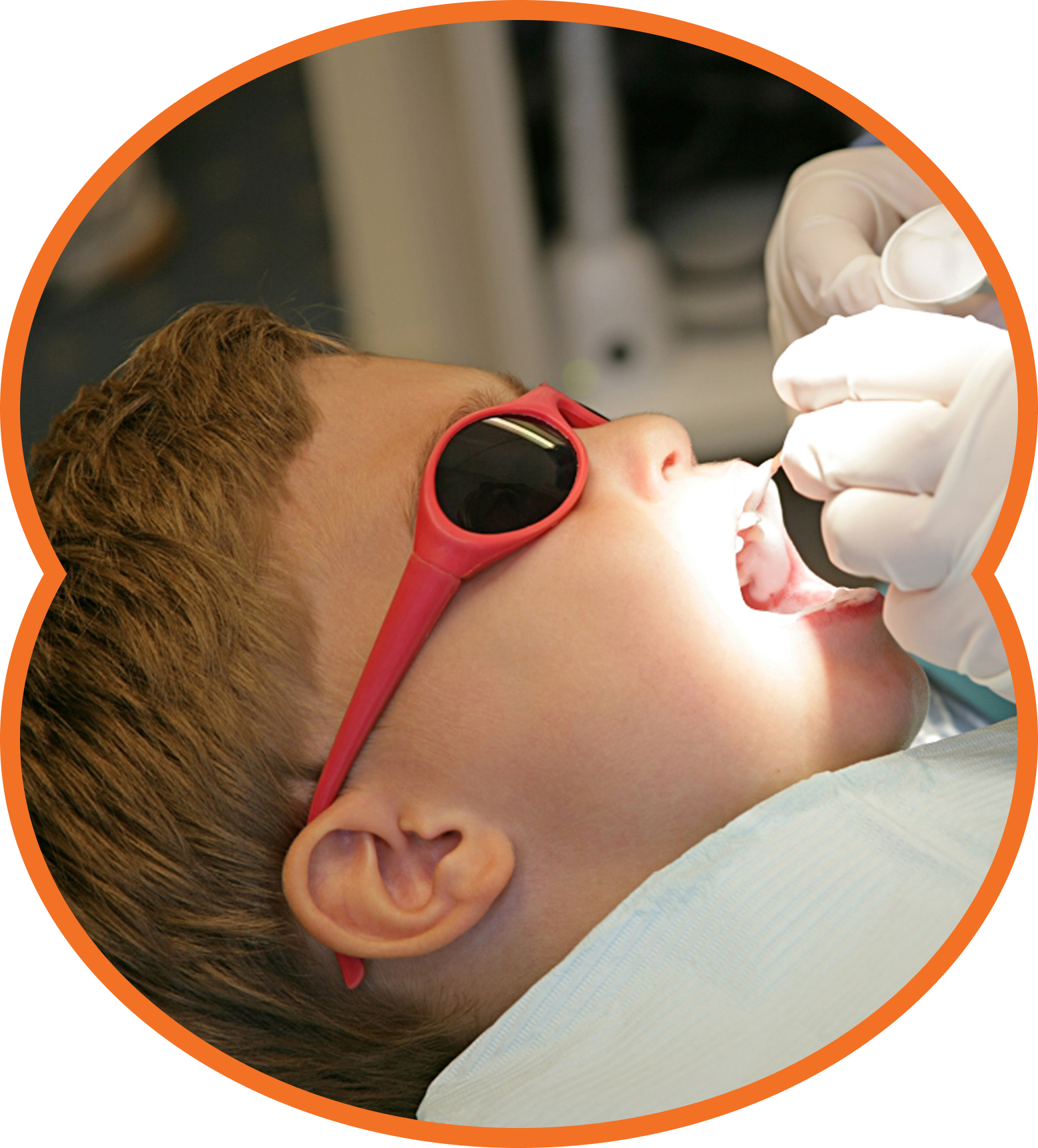 Girl at dentist, mouth open, receiving dental check-up with tools, blue gloves, white coat, close-up.