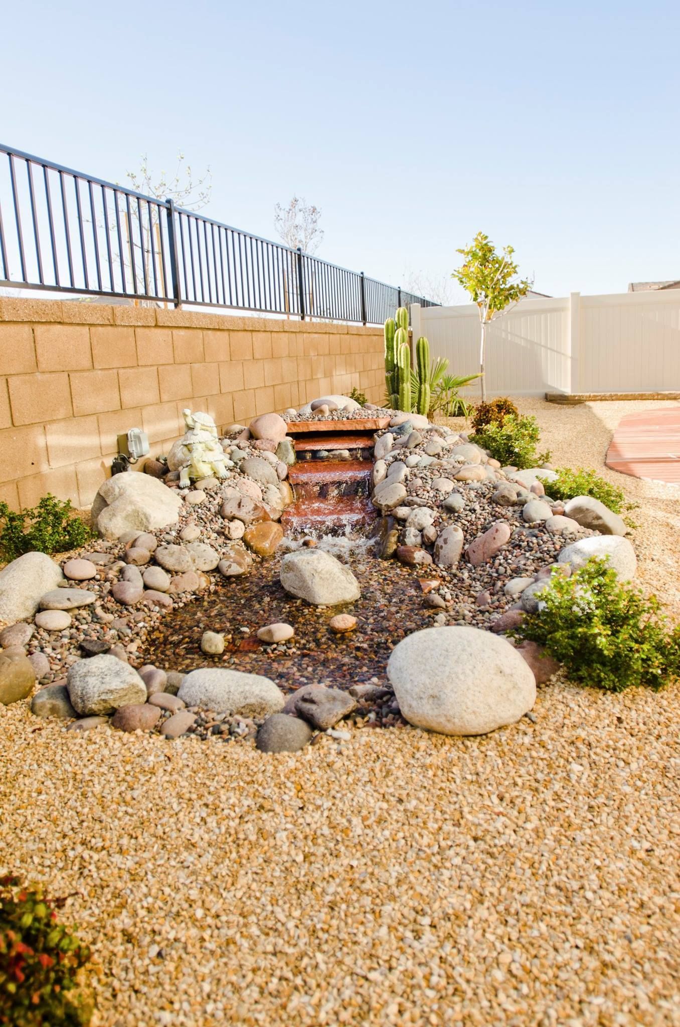 Small backyard water feature with rocks and gravel; tan and brown colors.