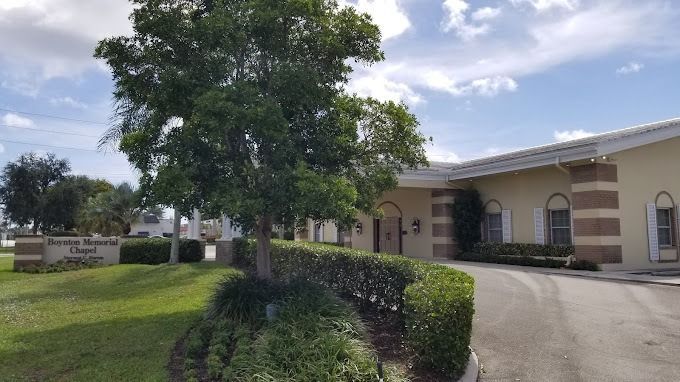 Exterior view of Boynton Memorial Chapel with lush green landscaping and a curved driveway.