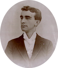 A black and white photo of a young man in a tuxedo