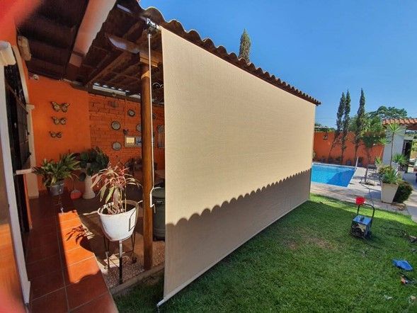 Un toldo blanco cuelga del costado de un edificio en un patio trasero.