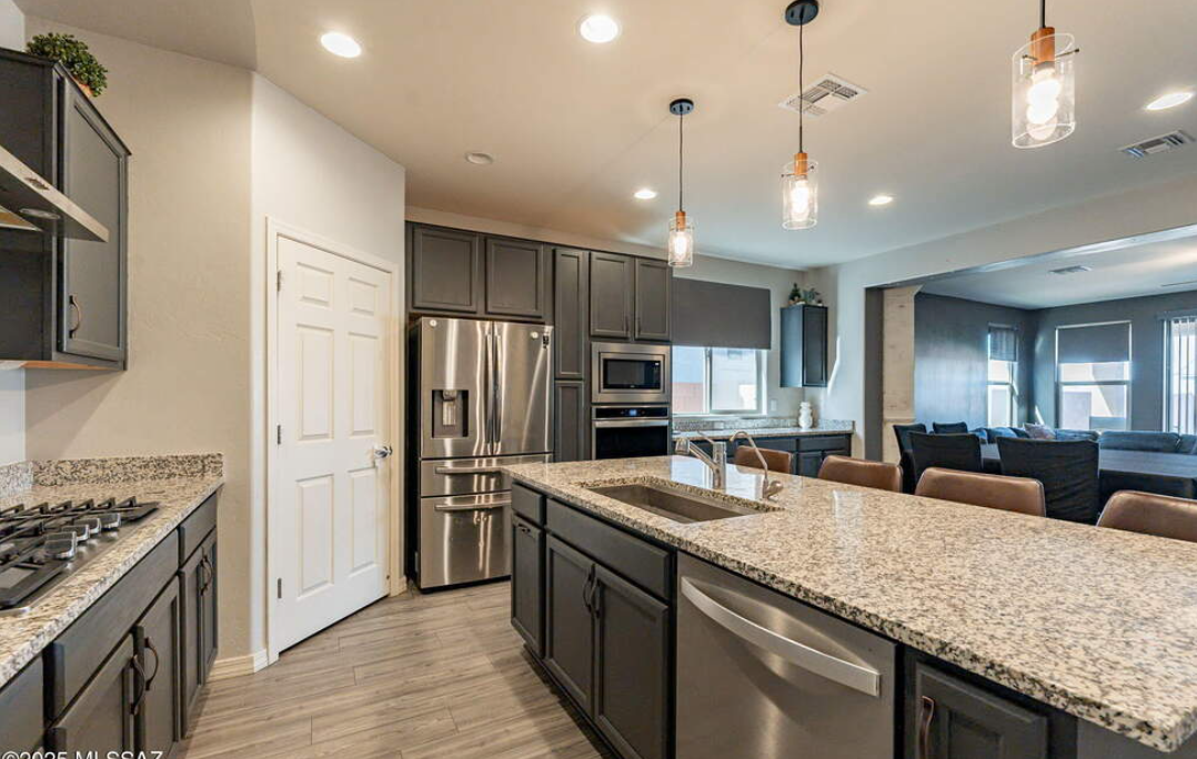 A living room with a couch , chairs , ottoman and a mirror