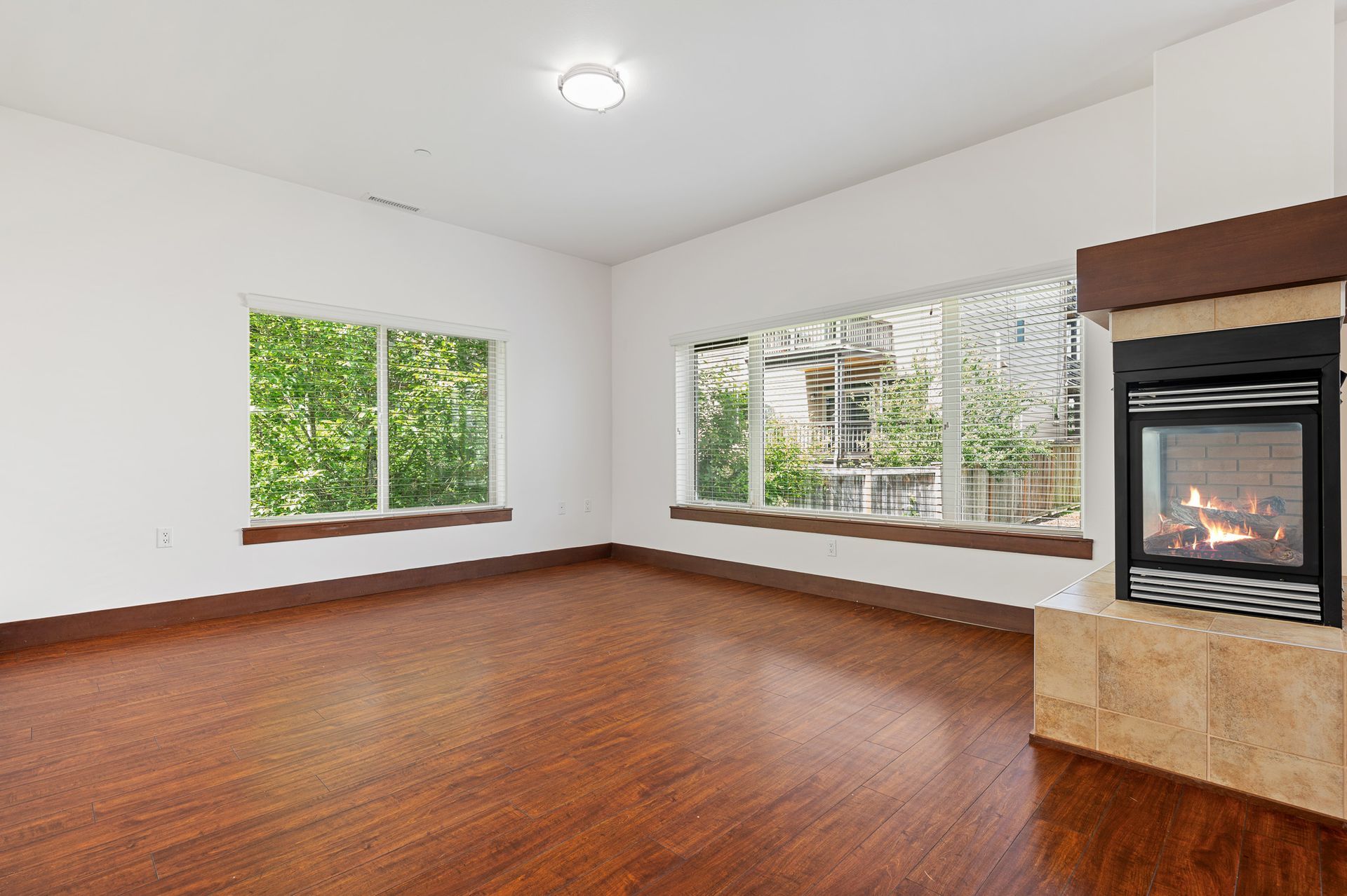 Photo of a fireplace at the edge of the photo, and a room with plenty of natural lighting