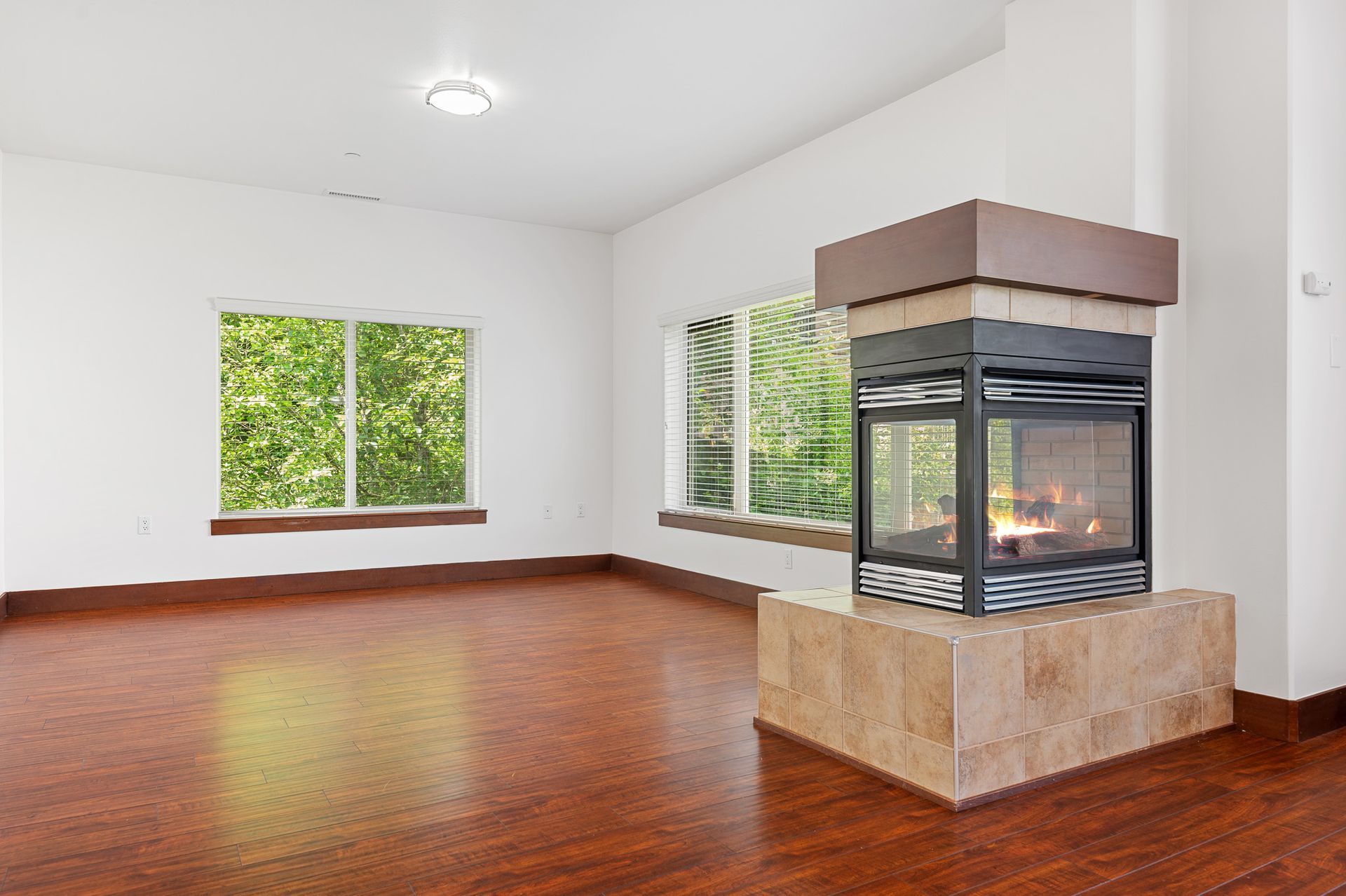 Photo of a huge living room, showing windows allowing for plenty of natural lighting, as well as a fireplace