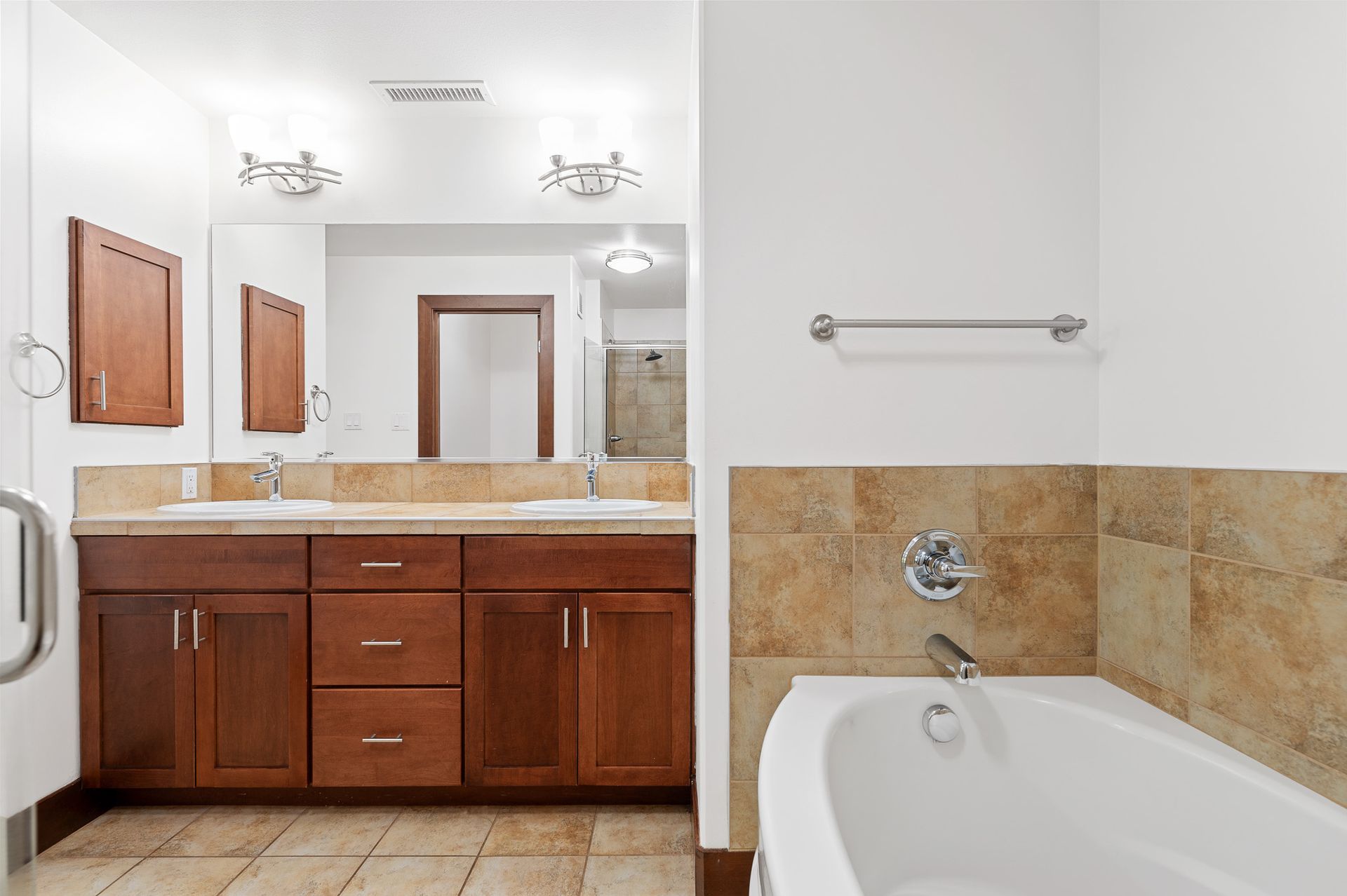Photo of a bathtub with a dual-sink counter in the background