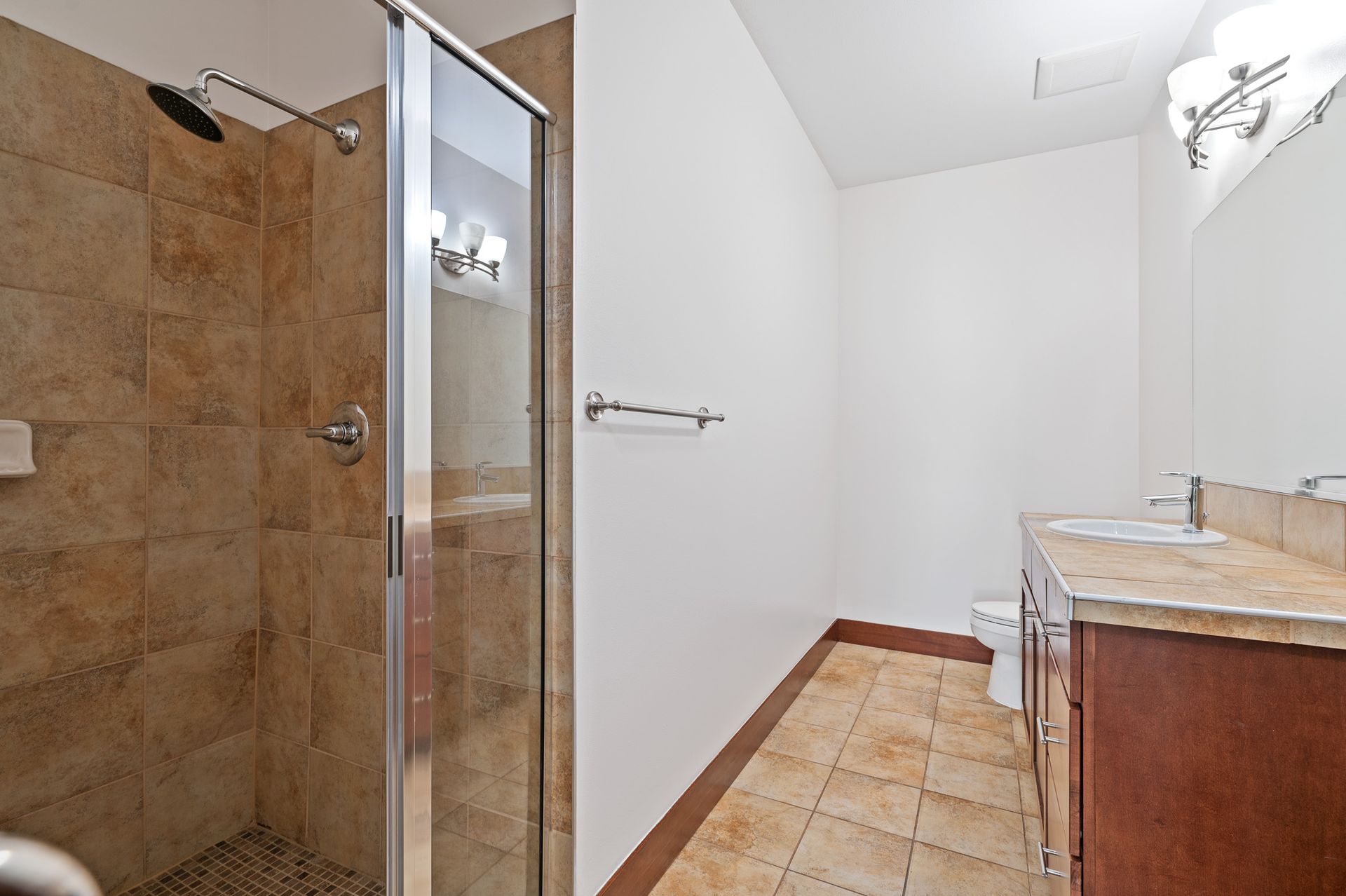 Photo of a bathroom, showing a long wall leading to a toilet