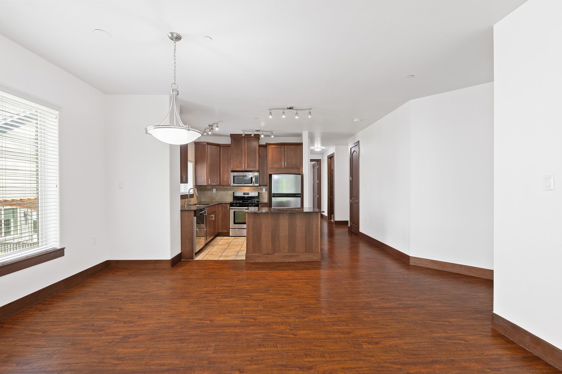 Photo of a large dining area, and the kitchen and hallway entrance in the background