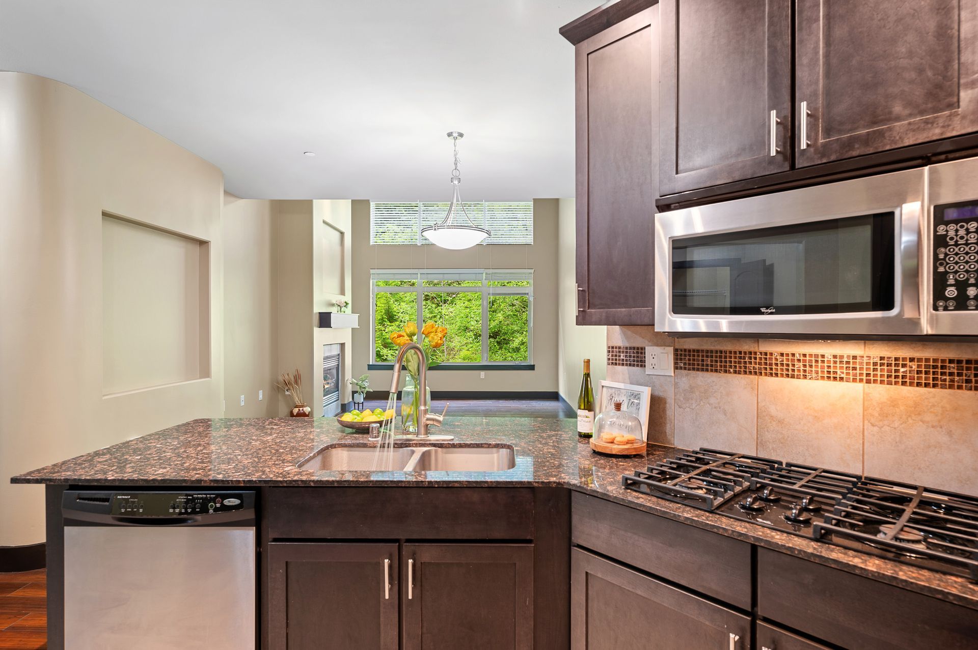 Photo of the kitchen sink and stove, with the living room in the background