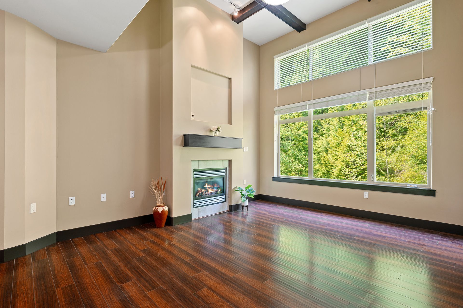 Photo of the living room showing a very large window, with a separate, also large windo above it
