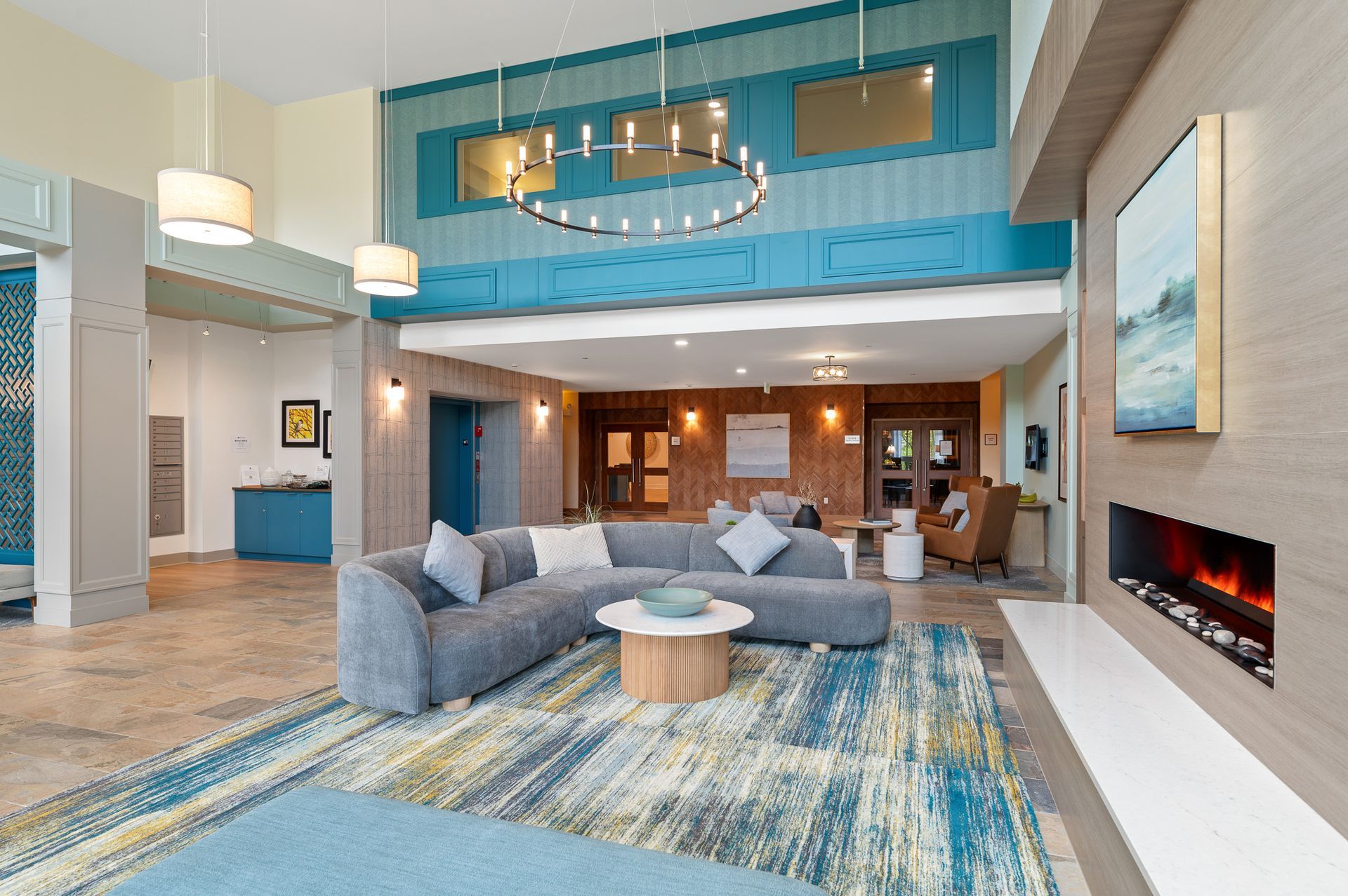 Photo of the l-shaped couch in the lobby, as well as a fireplace