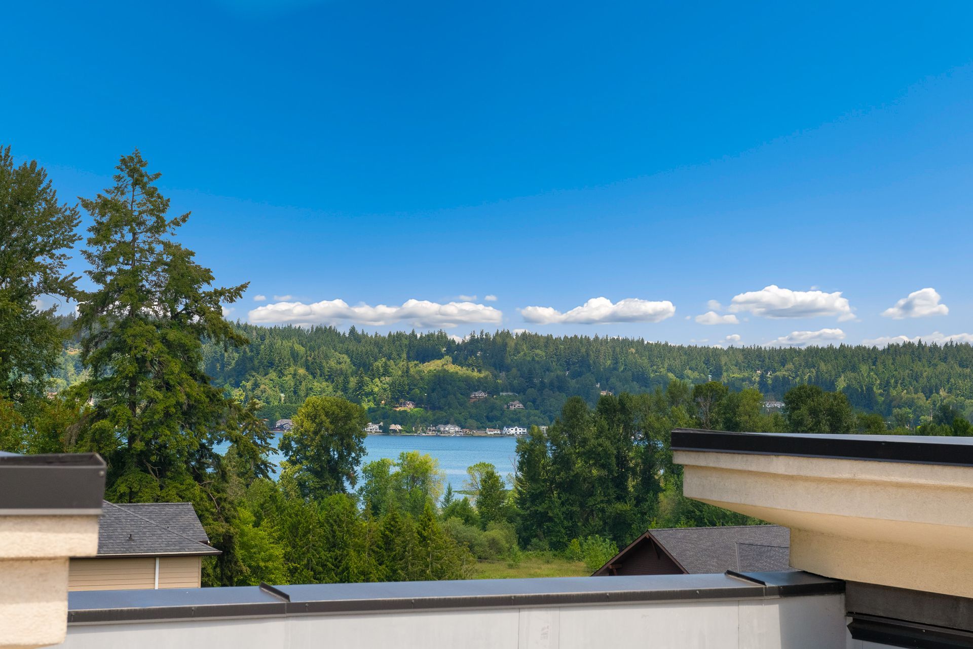 Photo of the view from the rooftop, showing a nearby body of water, as well as trees and hills