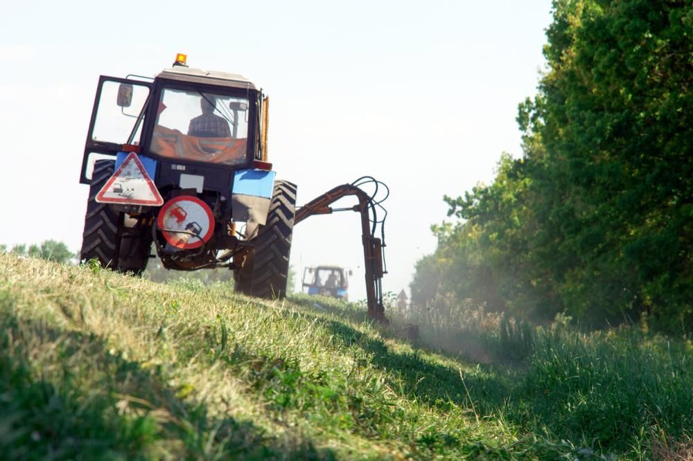 A Tractor is Cutting Grass in a Field — J.A. Slashing in Smithfield, QLD