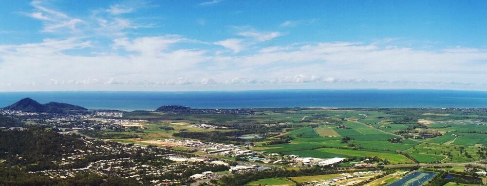 An Aerial View of a City and a River With Mountains in the Background — J.A. Slashing in Smithfield, QLD