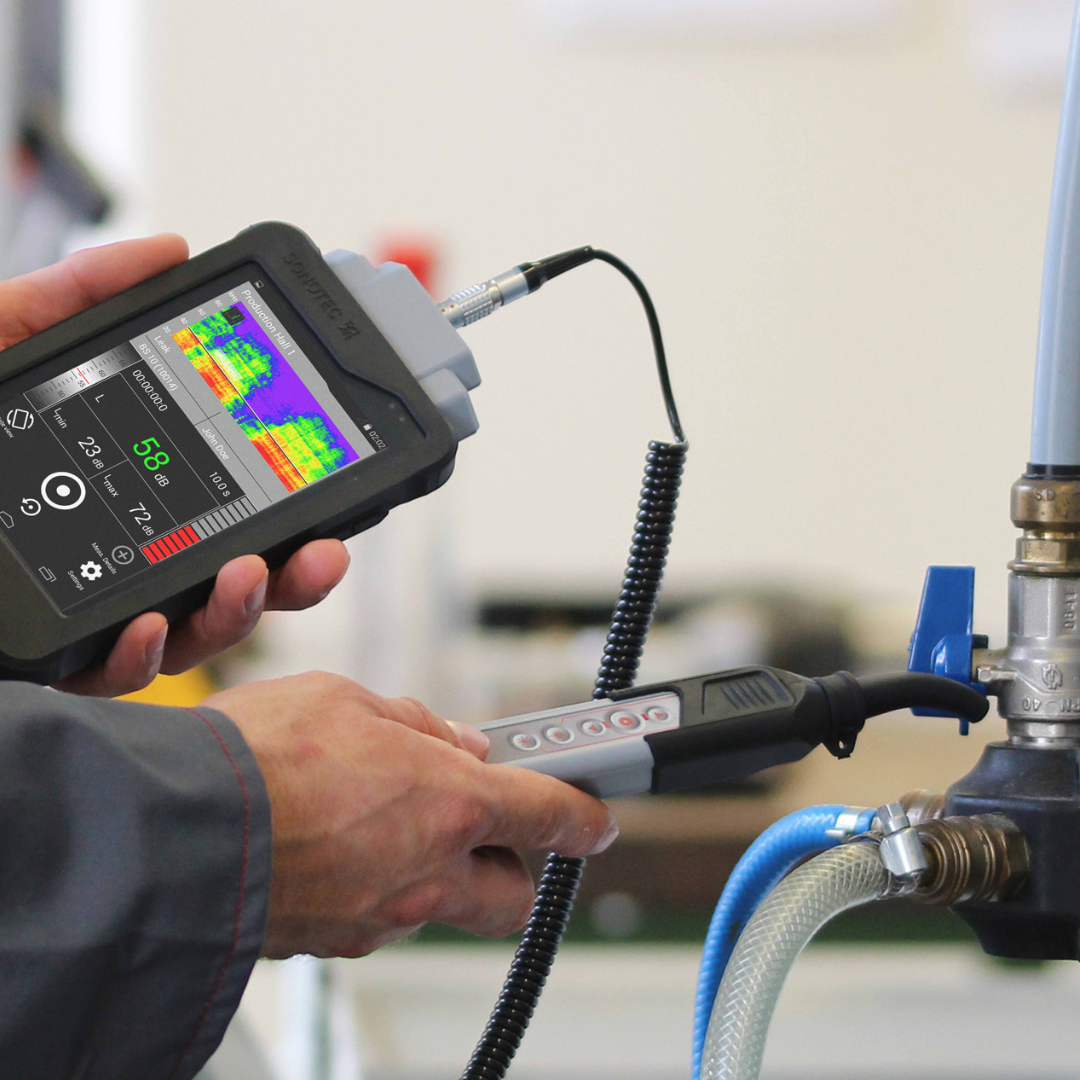 A man is sitting on a ladder cleaning a window.