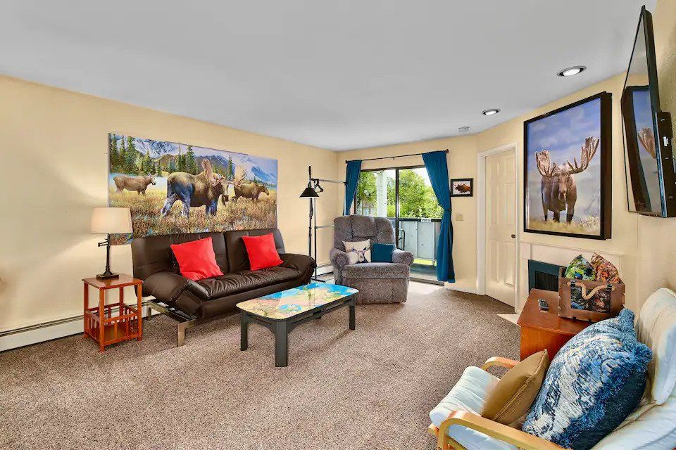 a living room with a couch , chair , coffee table , and television .