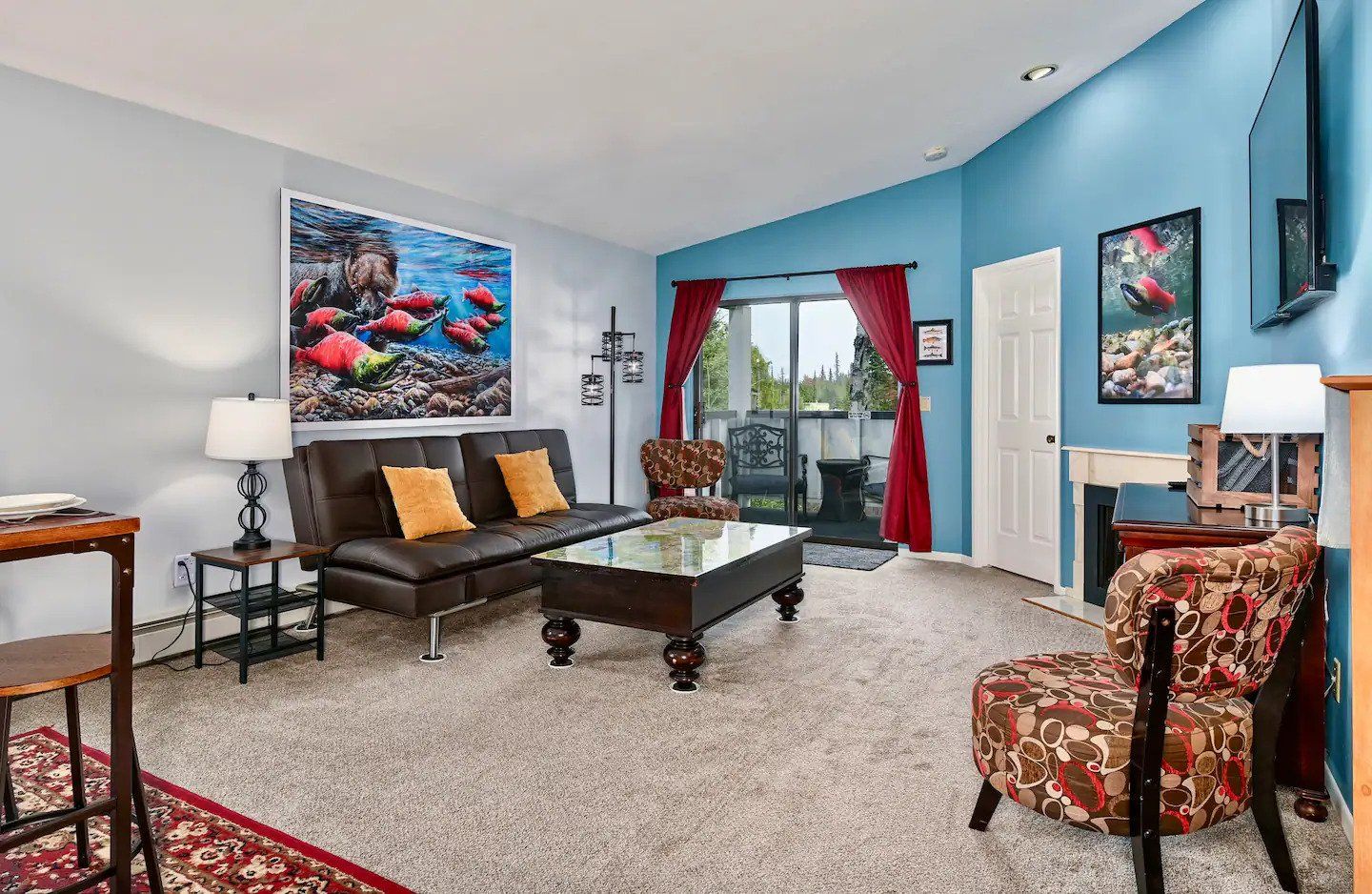 a living room with a couch , chairs , coffee table and television .