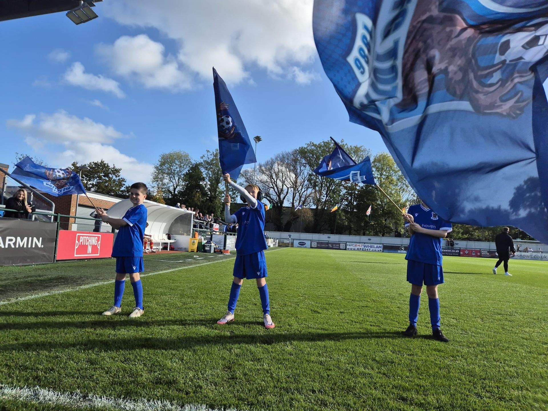 image of U9 Reds team waving flags on the snows pitch