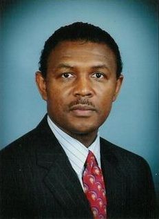 The front door of a house with a porch and plants in front of it.